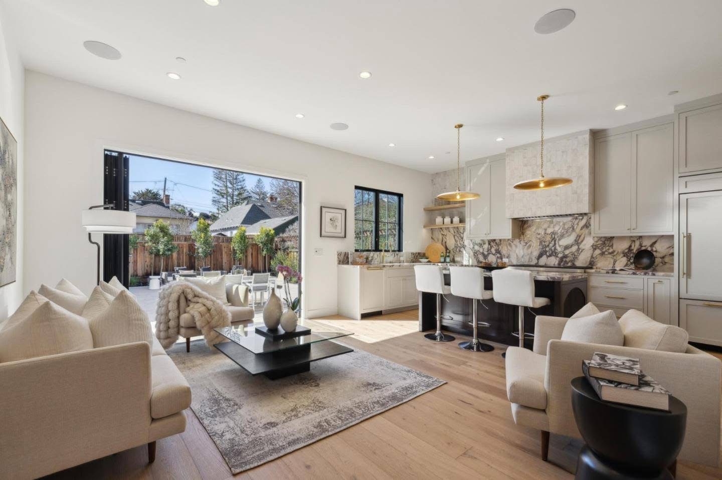 Open concept living area with large sliding doors opening to outdoor patio